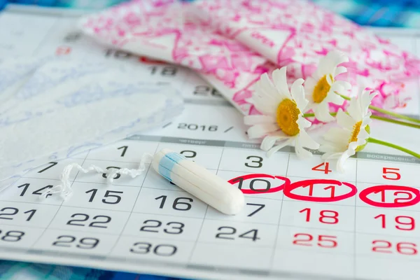 Γυναίκα υγιεινή προστασία, στενή up.menstruation ημερολόγιο με βαμβάκι επιχρίσματα, λευκό μαργαρίτες, υγειονομικών χαρτοπετσέτες σε ανοιχτόχρωμη επιφάνεια — Φωτογραφία Αρχείου