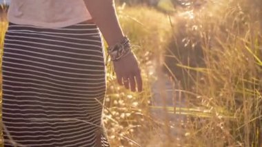 Kadın eğreltiotu yolundan gidiyor. Kız el çim dokunmadan. Güneş mercek parlaması