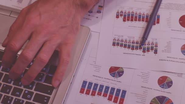 Mand på arbejde om aftenen, hjemme kontor, med nogle diagrammer og notesbog skrive – Stock-video