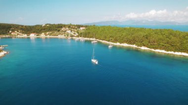 Kefalonya 'da yaz aylarında Fiskardo kasabası yakınlarındaki turkuaz körfezde katamaran yelken açıyor.