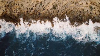 Erotik kayalıklar, kayalık kıyı sahnesinde enerjik deniz dalgalarıyla karşılaşıyor..