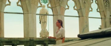 İtalya 'da heykelin yanındaki Duomo di Milano Katedrali' nin terasında bir kadın..