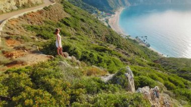 Yunanistan 'da Kefalonia tepesinden Petani Plajı' na bakan elbiseli kadın..