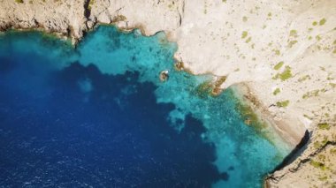 Kefalonya sahilinde kayalık kıyı şeridi ve derin mavi deniz suyuyla turkuaz koy..