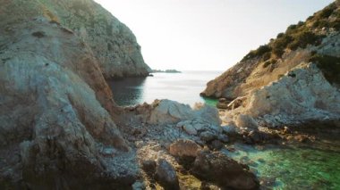 Kefalonia 'daki kayalık sahil şeridi. Güneş doğarken turkuaz su ve dramatik uçurumlar..