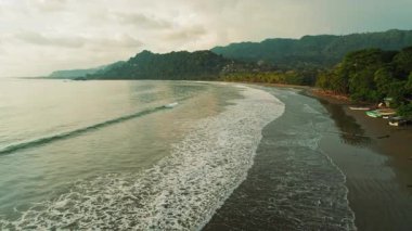 Kosta Rika 'da gün batımında Dominicalito plajında dalgaların dalgalanması.