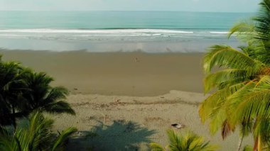 Sakin okyanus dalgalarına doğru yürüyen tek bir kişinin olduğu engin bir kumsal..