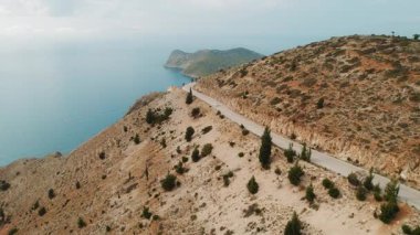 Kefalonia adasındaki sahil yolu. Kayalık yamaç boyunca araba sürüyor..