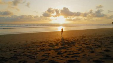 Kosta Rika 'da altın saatinde Ostional Kumsalda Koşan Kadın.