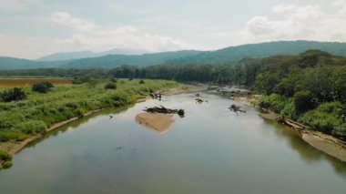 Tarcoles Nehri 'nin manzarası ve Kosta Rika kırsalındaki yeşil dağlar.