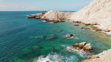 Turkuaz deniz dalgaları Yunan adası Kefalonia 'daki kayalık kıyı şeridini yıkıyor.