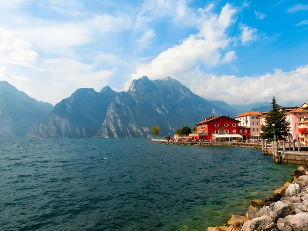 Torbole, Italia - 21 de septiembre de 2014: Paseo marítimo por el lago de Garda con casas, turistas y barcos — Foto de Stock