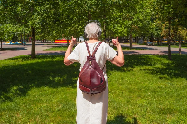 Graue Seniorin zeigt Daumen nach oben im Park — Stockfoto