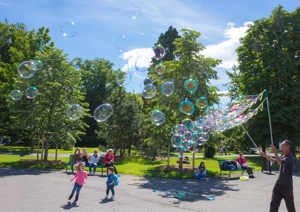 Geneva, Switzerland - June 17, 2016: The children and with soap bubbles attraction at park — Stock Photo, Image
