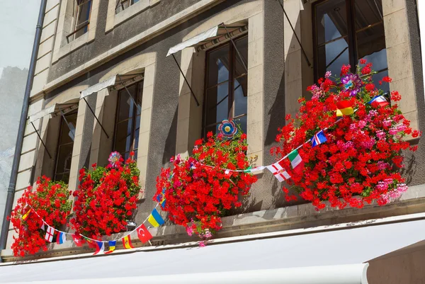 Vintage ventana con flores y banderas, Ginebra, Suiza —  Fotos de Stock