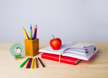 Geri okul arka plan için kitap, kalem ve ahşap masa üzerinde elma