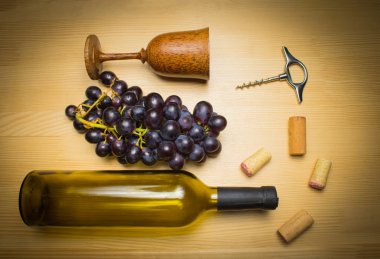 Ahşap arka planda tirbuşonlu bir şişe şarap.