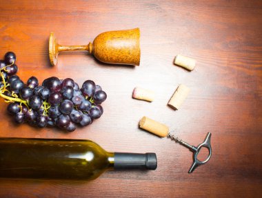 Ahşap arka planda tirbuşonlu bir şişe şarap.