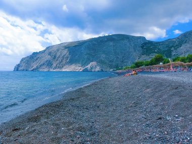 Santorini, Yunanistan - 10 Haziran 2015: 10 Haziran 2015 'te Yunanistan' ın Santorini kentinde siyah kumsalda dinlenen insanlar