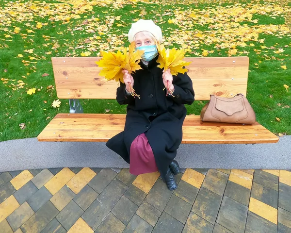 Mulher Mais Velha Máscara Protetora Buquê Folhas Outono Está Divertindo — Fotografia de Stock