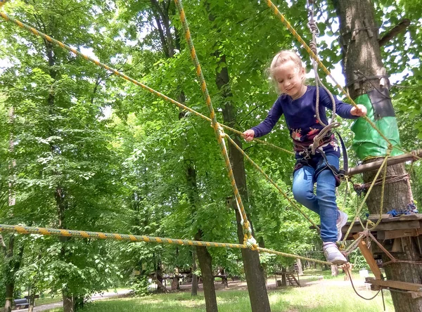 Das Mädchen Klettert Abenteuer Seilpark Gegen Grüne Bäume — Stockfoto