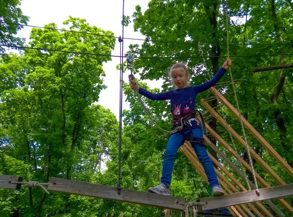 Das Mädchen Klettert Abenteuer Seilpark Gegen Grüne Bäume — Stockfoto