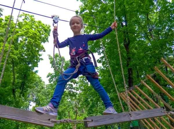 Das Mädchen Klettert Abenteuer Seilpark Gegen Grüne Bäume — Stockfoto