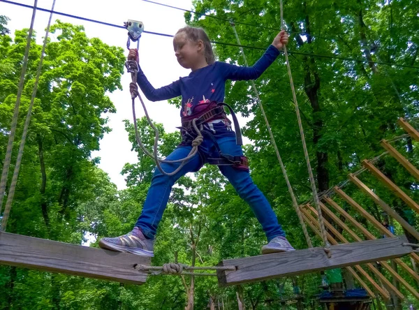 Das Mädchen Klettert Abenteuer Seilpark Gegen Grüne Bäume — Stockfoto