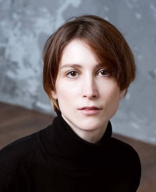 Stüdyoda büyük üzgün gözleri olan genç bir kadının portresi.