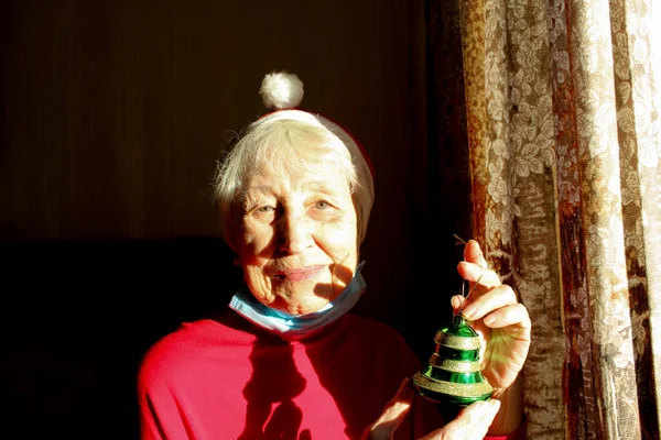 Старшая Женщина Возле Окна Солнечное Утро Шляпе Санты Носит Медицинскую — стоковое фото