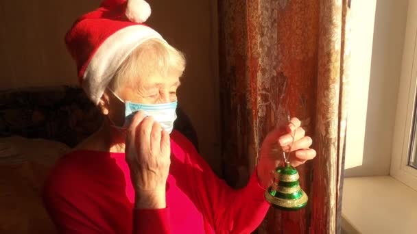Oudere Vrouw Bij Het Raam Zonnige Ochtend Met Een Kerstmuts — Stockvideo