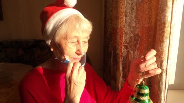 Oudere Vrouw Bij Het Raam Zonnige Ochtend Met Een Kerstmuts — Stockvideo
