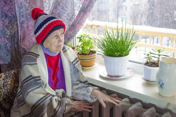 Старшая Женщина Сидящая Перед Обогревателем Оплата Отопление Зимой — стоковое фото