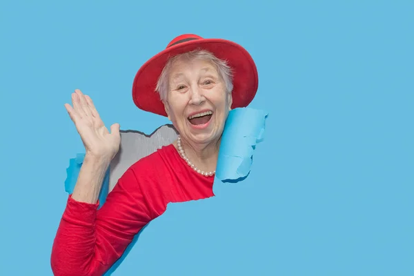 Удивлена Пожилая Женщина Смотрит Сквозь Дыру Бумажной Стене Потрясенная Леди — стоковое фото