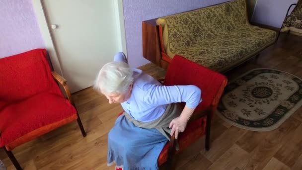 Idosos sênior 75s mulher com sentimentos dolorosos na lombar, massageando lombar para reduzir a dor, sofrem de desconforto nas costas. — Vídeo de Stock