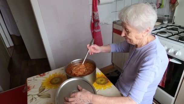 Senior kvinna matlagning kikärter soppa hemma kök — Stockvideo