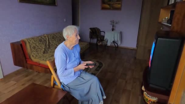 De oudere vrouw die thuis tv kijkt. — Stockvideo