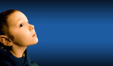 Mavi arka planda afallamış bir çocuğun portresi. Küçük izleyici kavramı