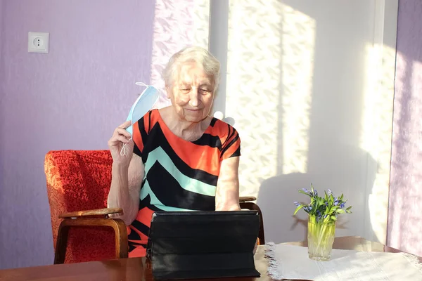 COVID-19 Stay connected. Happy senior woman at home video calling family on laptop or online chatting with long distance friends. Coronavirus lockdown, Hope, connections and technology concept.