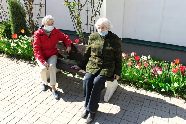 Les femmes âgées en distanciation sociale assis au parc. — Photo