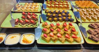 Açık büfedeki raflarda bulunan yiyecekler, Türkiye 'de soyut otel veya Kemer' deki tatil beldesindeki her şeyi kapsıyor. Tatlı kekler ve tatlı