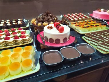 Açık büfedeki raflarda bulunan yiyecekler, Türkiye 'de soyut otel veya Kemer' deki tatil beldesindeki her şeyi kapsıyor. Tatlı kekler ve tatlı