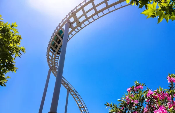 Streszczenie Jazdy Rollercoaster Przed Niebieskim Niebem Kwiaty — Zdjęcie stockowe
