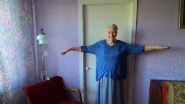 Evdeki oturma odasında jimnastik yaparken son sınıf öğrencisi bir kadın..