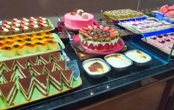 Food on the shelves in the self-service buffet with all inclusive in Turkey at abstract hotel or resort at Kemer. Sweet cakes and dessert