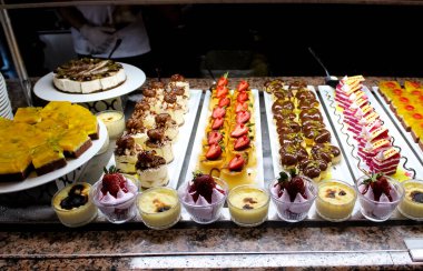 Açık büfedeki raflarda bulunan yiyecekler, Türkiye 'de soyut otel veya Kemer' deki tatil beldesindeki her şeyi kapsıyor. Tatlı kekler ve tatlı