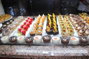 Açık büfedeki raflarda bulunan yiyecekler, Türkiye 'de soyut otel veya Kemer' deki tatil beldesindeki her şeyi kapsıyor. Tatlı kekler ve tatlı