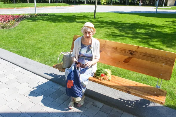 Female hands holding empty purse after shopping at park. Senior woman shows her empty wallet. Bankruptcy. The concept of poverty.