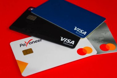 Kyiv, Ukrayna - 18 Nisan 2021: Mastercard Payonez kartı kırmızı arkaplanı kapat. Paeveryone, çevrimiçi para transferi ve dijital ödeme hizmetleri sağlayan bir finans şirketidir..