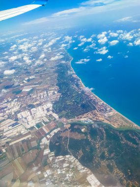 İniş sırasında Antalya 'nın hava görüntüsü. Akdeniz 'in mavi suları, güzel körfez, bir sürü küçük renkli ev ve sabah güneşiyle aydınlanan kumlu kumlu plaj.